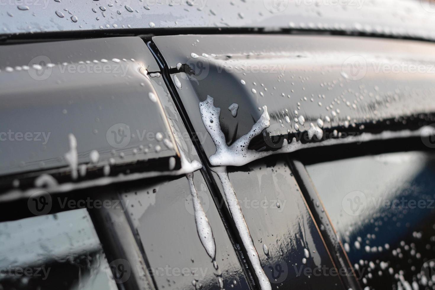 toutes les bulles coulent sur le rétroviseur de la voiture. laver la voiture. photo