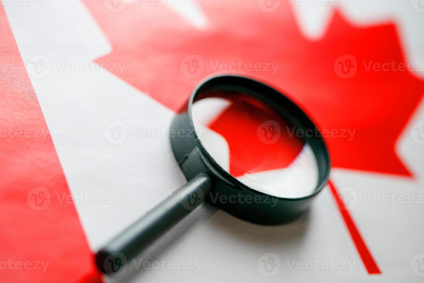 drapeau canadien regardant à travers une loupe. une étude de l'histoire et de la culture du peuple canadien. le concept d'étudier la géographie, les coutumes photo