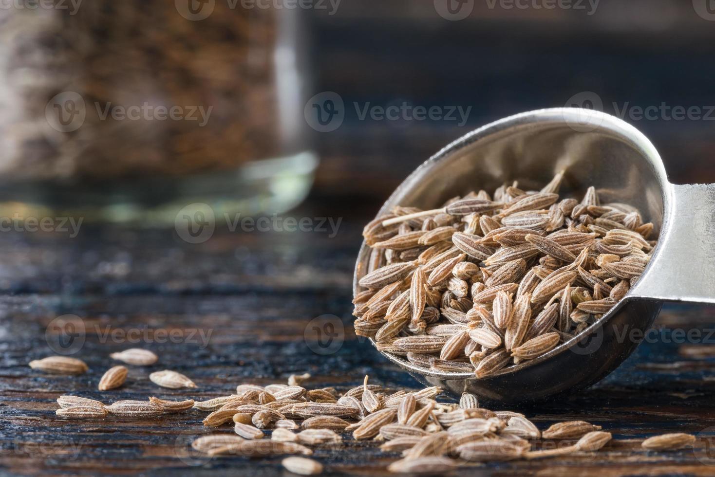 graines de cumin renversées d'une cuillère à café photo