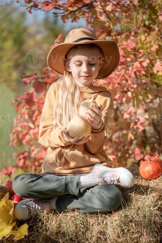 fille dans le foin avec des citrouilles photo