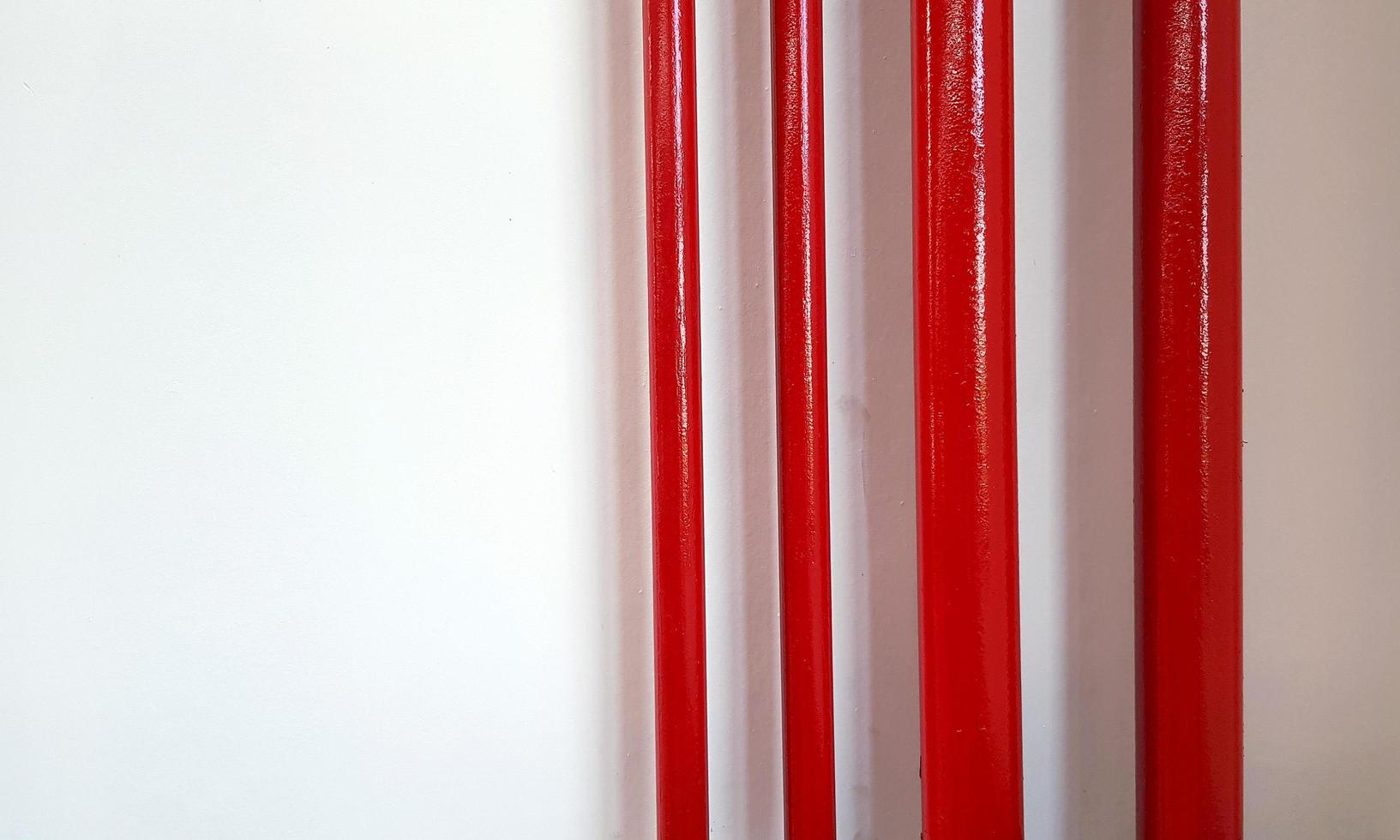 grand et petit pipeline rouge sur mur blanc avec espace de copie à droite. conduite de gaz ou d'eau et groupe d'objets. photo