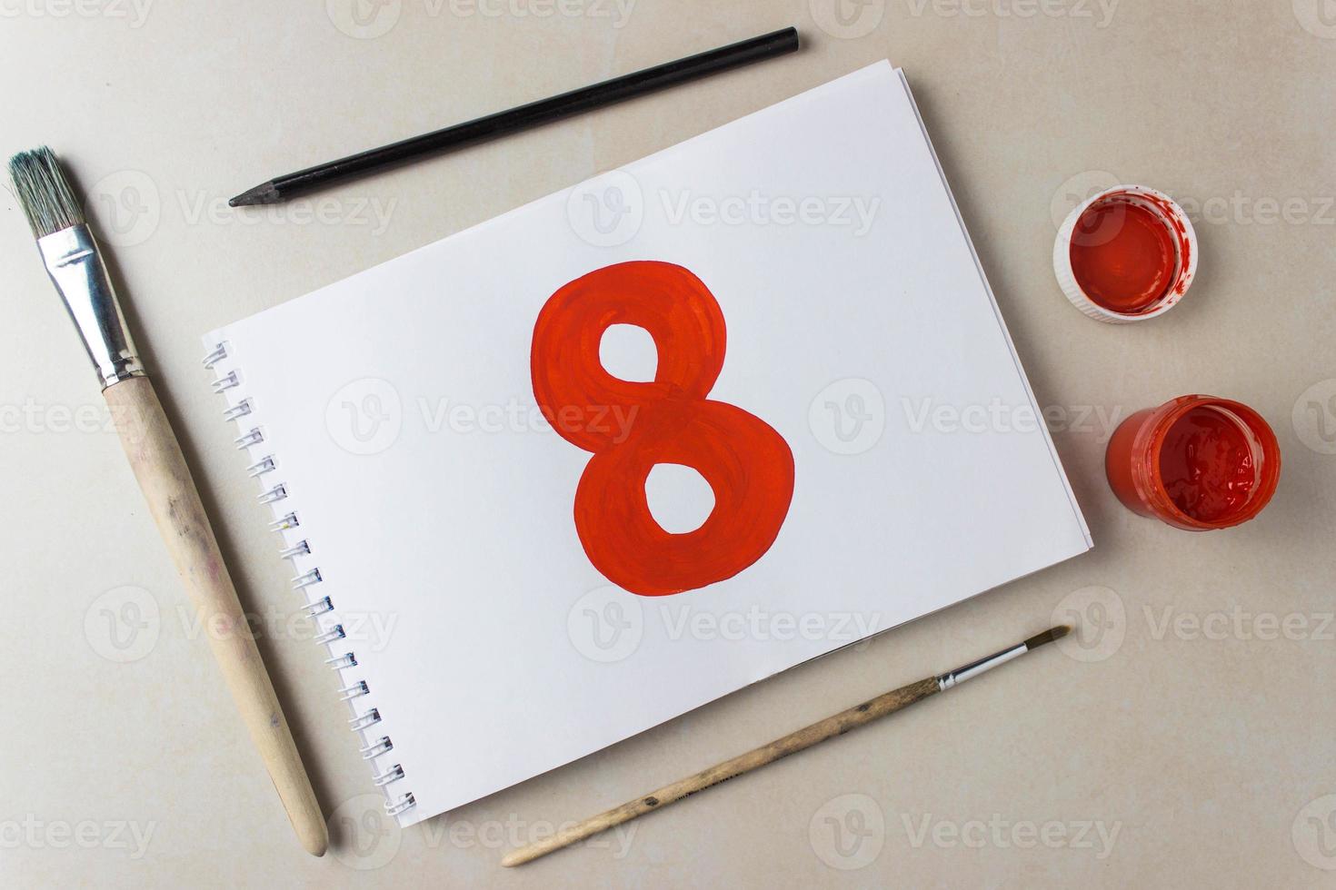 Numéro huit rouge dessin sur une feuille d'album blanc. photo