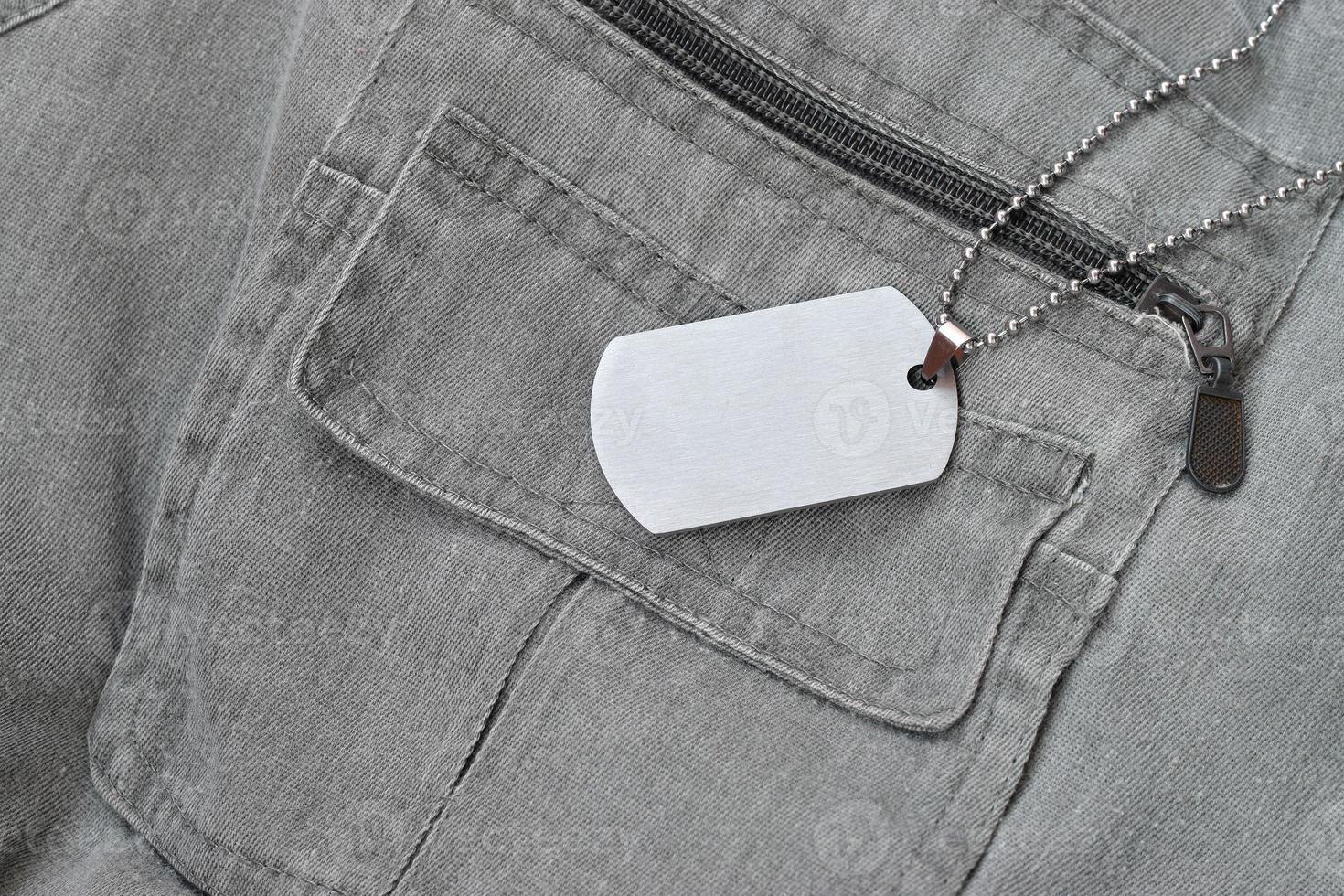 Perles militaires argentées avec étiquette de chien sur gilet gris foncé avec poches photo