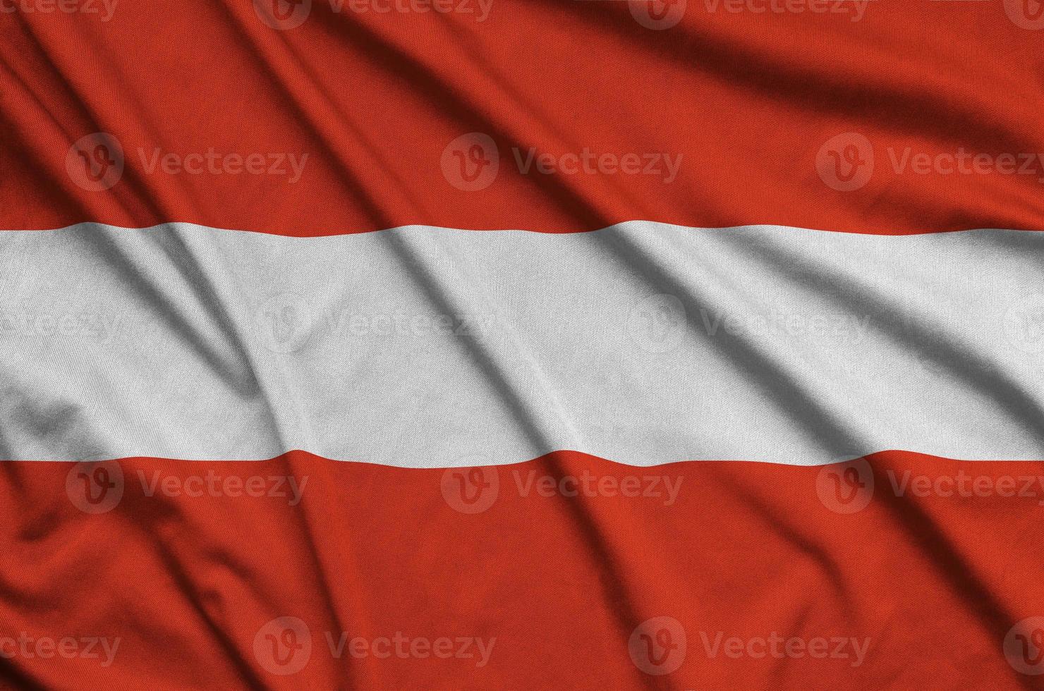 le drapeau autrichien est représenté sur un tissu de sport avec de nombreux plis. bannière de l'équipe sportive photo