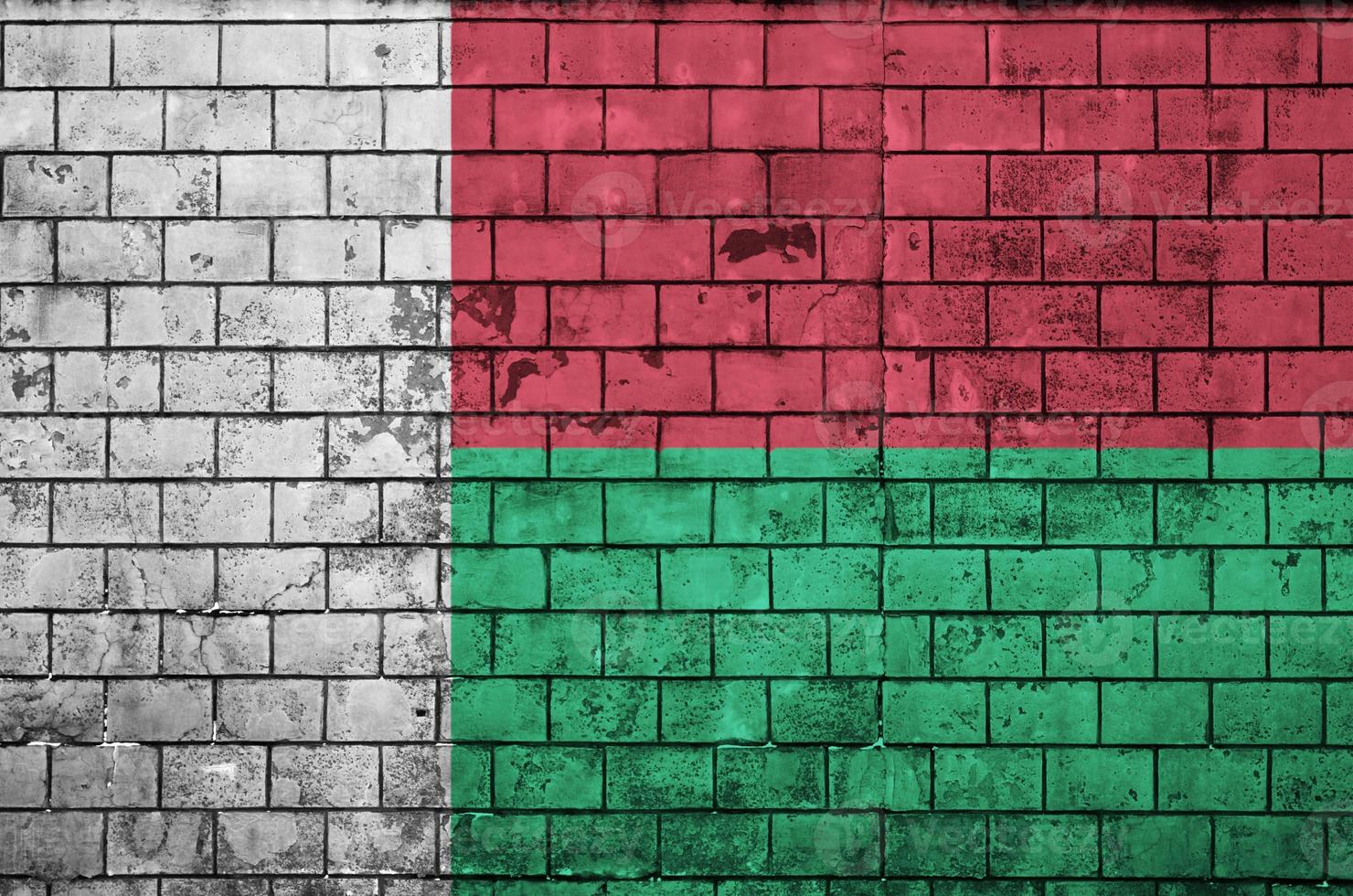 Le drapeau de Madagascar est peint sur un vieux mur de briques photo