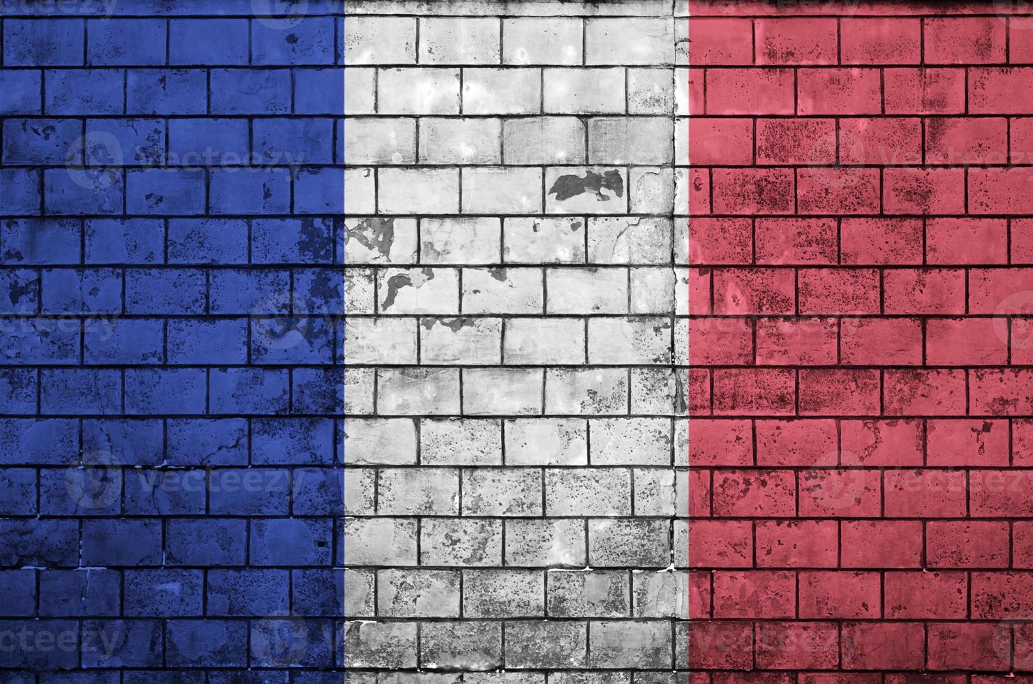 Le drapeau de la France est peint sur un vieux mur de briques photo