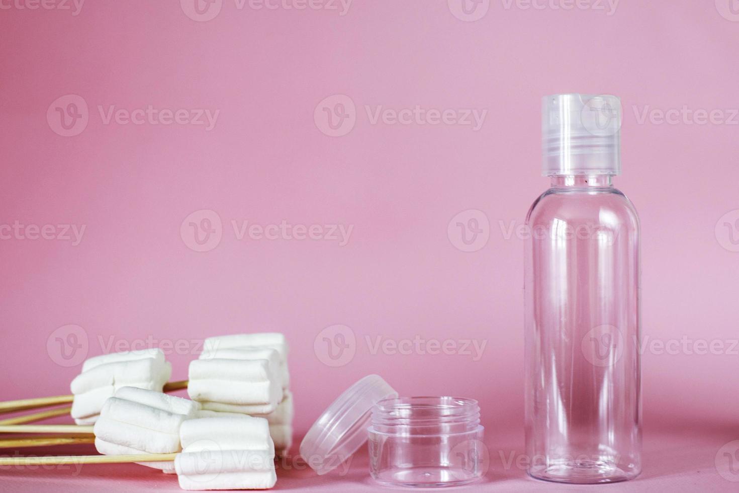 produits cosmétiques spa avec tube vide doux et transparent sur fond rose. bouteille en plastique pour agent de nettoyage détergent photo