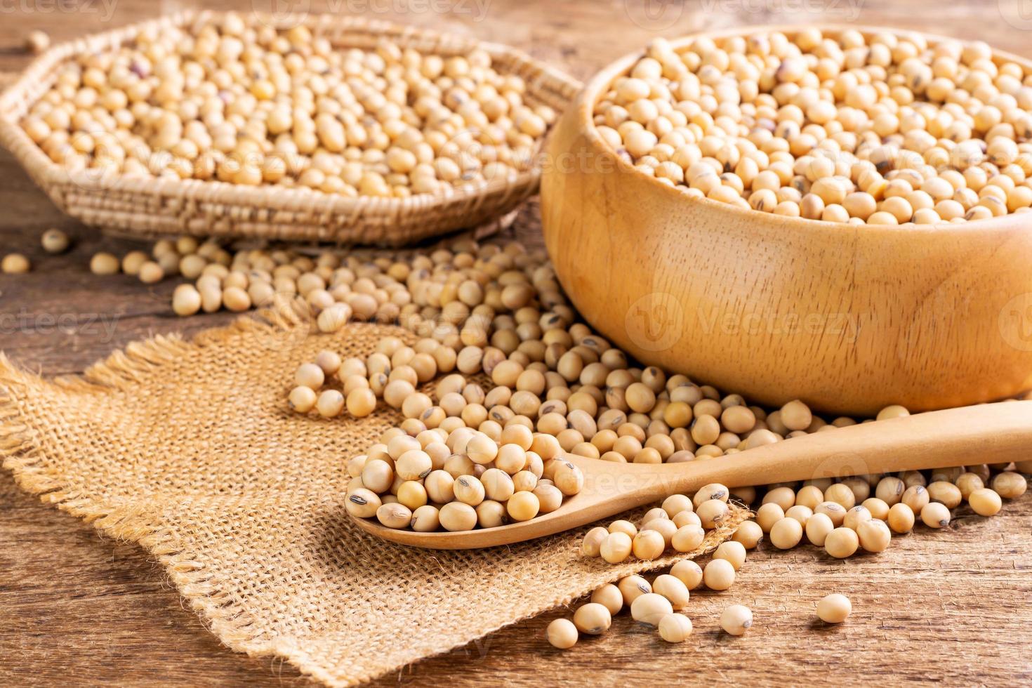 graines de soja dans une cuillère en bois, placées sur une table en bois, des graines ou des aliments sains naturels - vue de dessus. photo