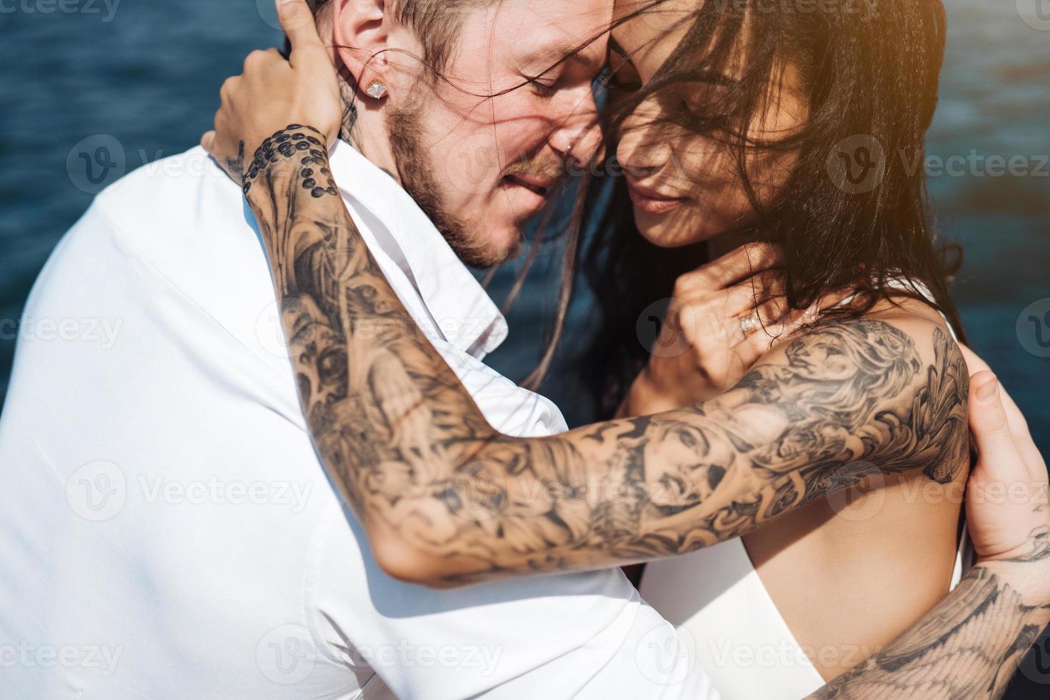 jeune couple est assis sur la jetée au bord de la mer photo