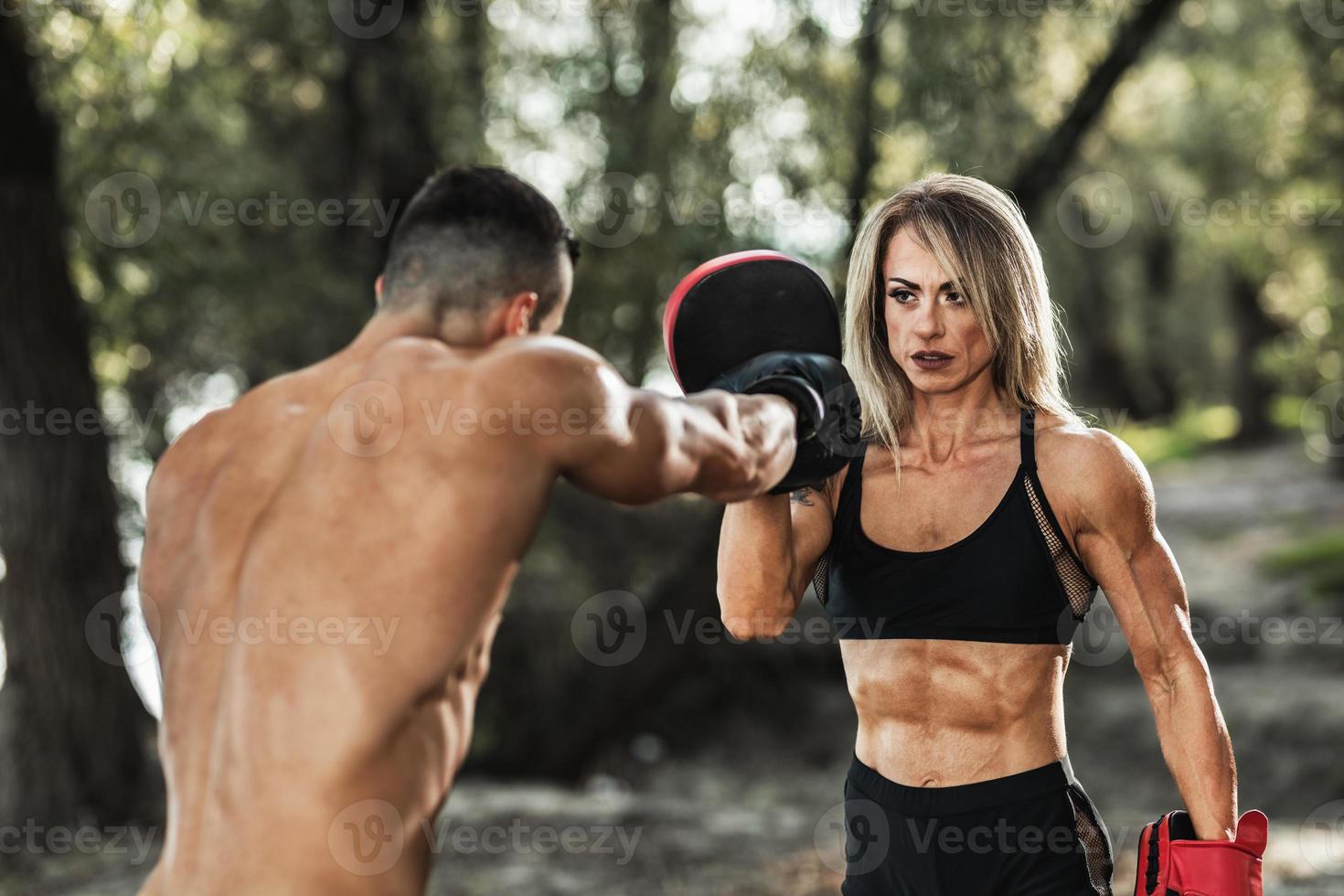 femme musclée faisant de l'entraînement de boxe en plein air avec son  entraîneur personnel 14233762 Photo de stock chez Vecteezy