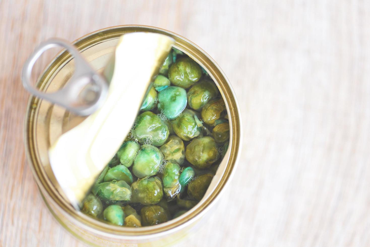 aliments en conserve dans une boîte métallique sur fond de bois , vue de dessus produits en conserve produits de stockage d'aliments non périssables dans la maison de cuisine , pois en conserve photo