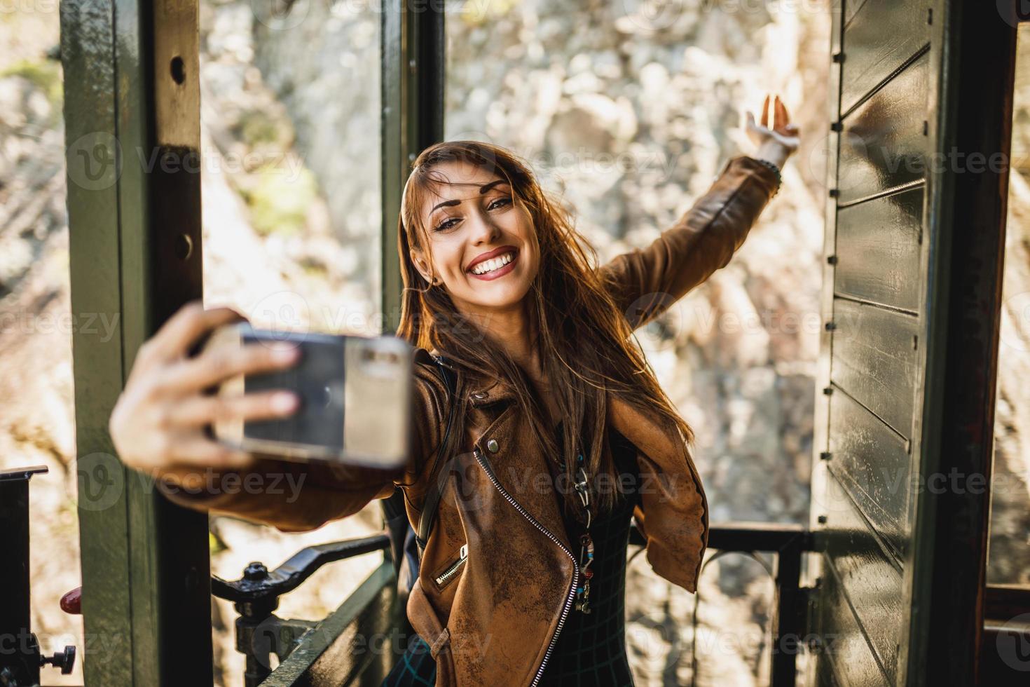 femme faisant un selfie par téléphone intelligent tout en voyageant en train rétro photo