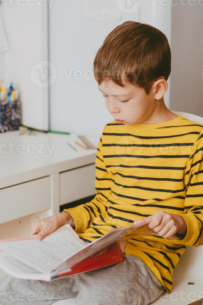 Fatigué De 8 Ans Garçon Faisant Ses Devoirs À La Table. Enfant Lisant Un  Livre Au Bureau. Banque D'Images et Photos Libres De Droits. Image 92629137