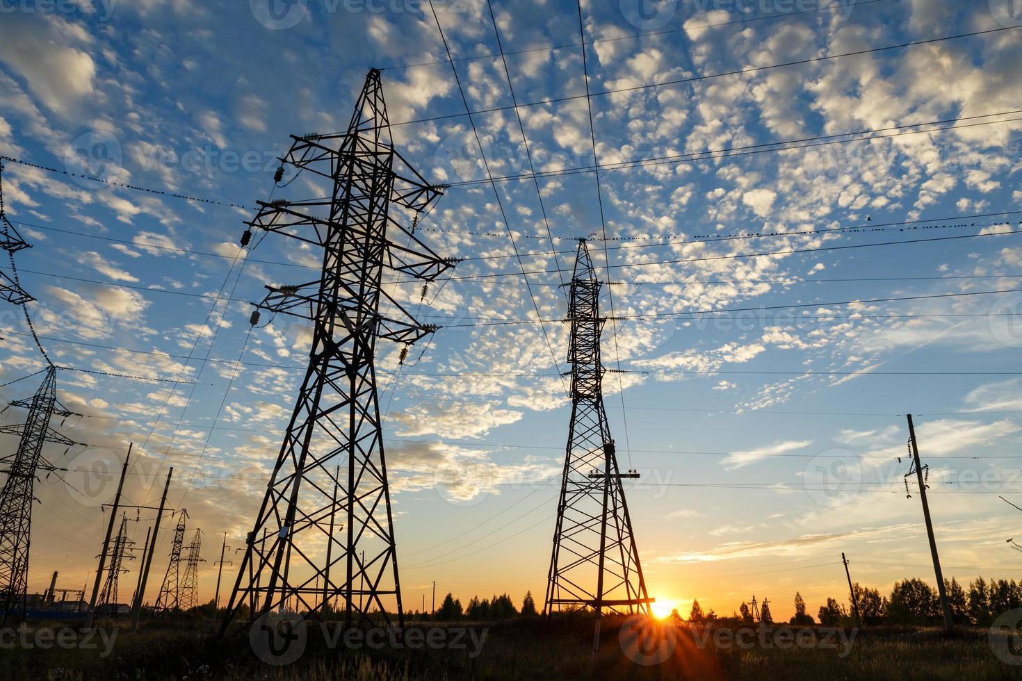 la ligne électrique haute tension prend en charge au coucher du soleil. photo