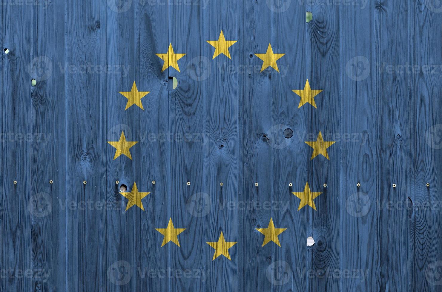 drapeau de l'union européenne représenté dans des couleurs de peinture vives sur un vieux mur en bois. bannière texturée sur fond rugueux photo