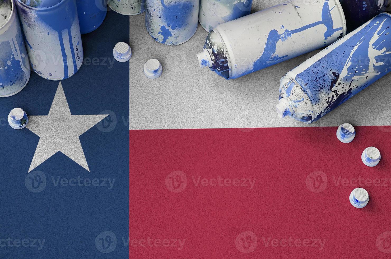 drapeau de l'état américain du texas et quelques aérosols utilisés pour la peinture de graffitis. concept de culture d'art de rue photo