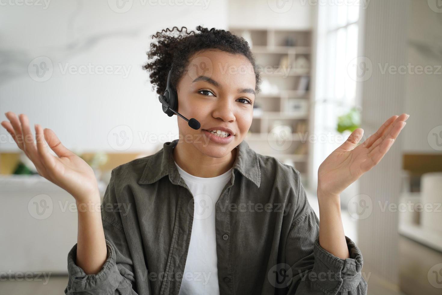 étudiante métisse dans le casque, regardant la caméra, discutant en ligne par appel vidéo. apprentissage en ligne photo