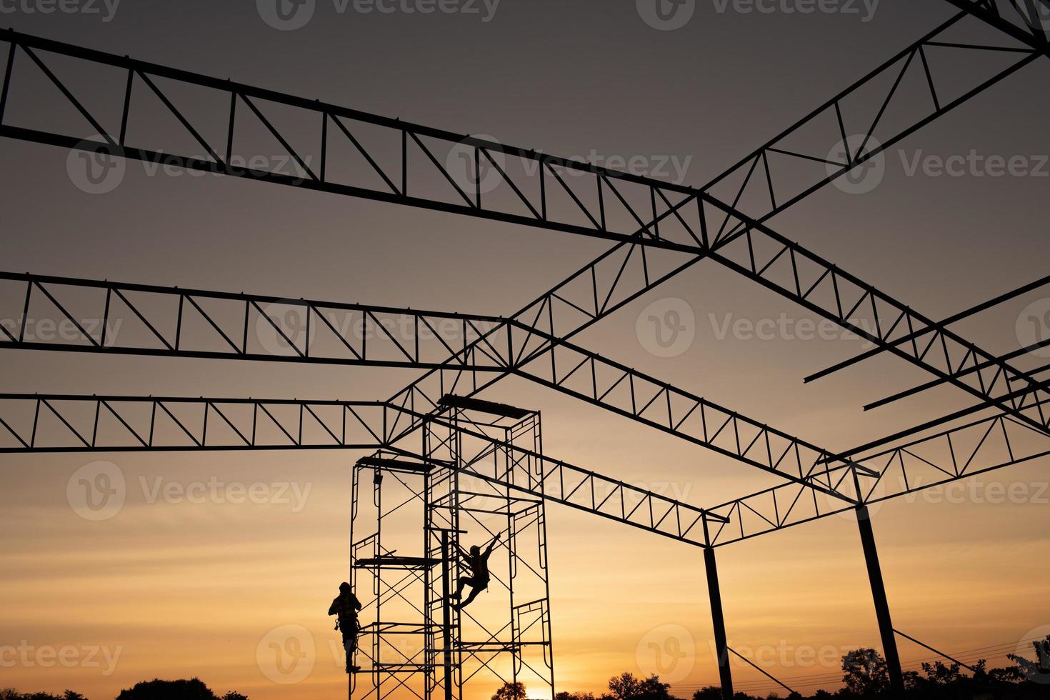 silhouette, ouvrier construction, travailler, échafaudage, dans, industriel, construction, pendant, coucher soleil, ciel, fond, sur, temps, travail photo