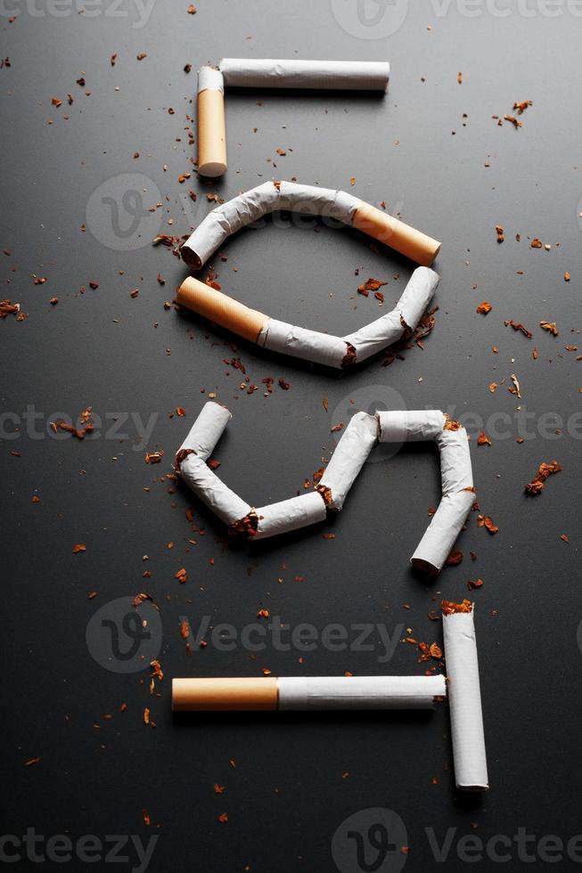 l'inscription perdue des cigarettes sur fond noir. arrêter de fumer. le concept de fumer tue. inscription de motivation pour arrêter de fumer, habitude malsaine. photo