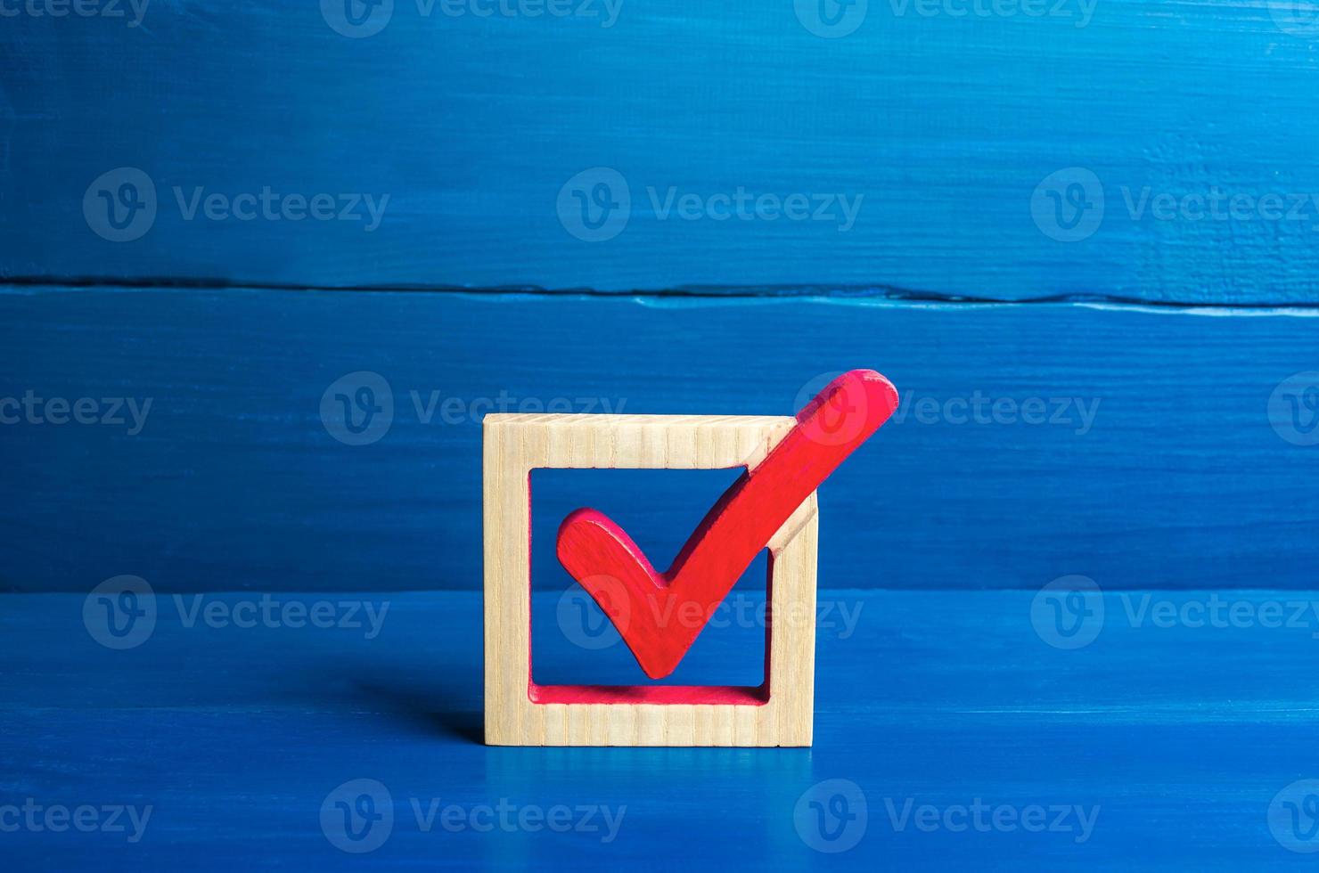 coche de vote rouge sur fond bleu. concept de vote pour des élections démocratiques. faire le meilleur choix, résoudre le problème. sondage social. droits et libertés. légiférer. symbole d'approbation photo