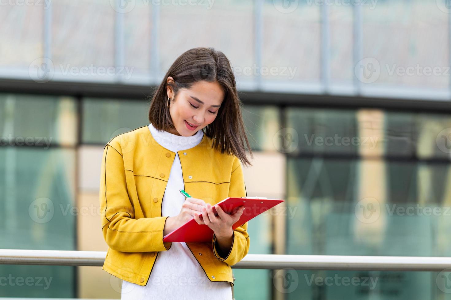 femme d'affaires asiatique en tenue décontractée écrivant sur le  presse-papiers. femme d'affaires tenant le presse-papiers. femme moderne et  travailleuse tenant un presse-papiers dans les mains, écrivant sur des  documents. 14260214 Photo de