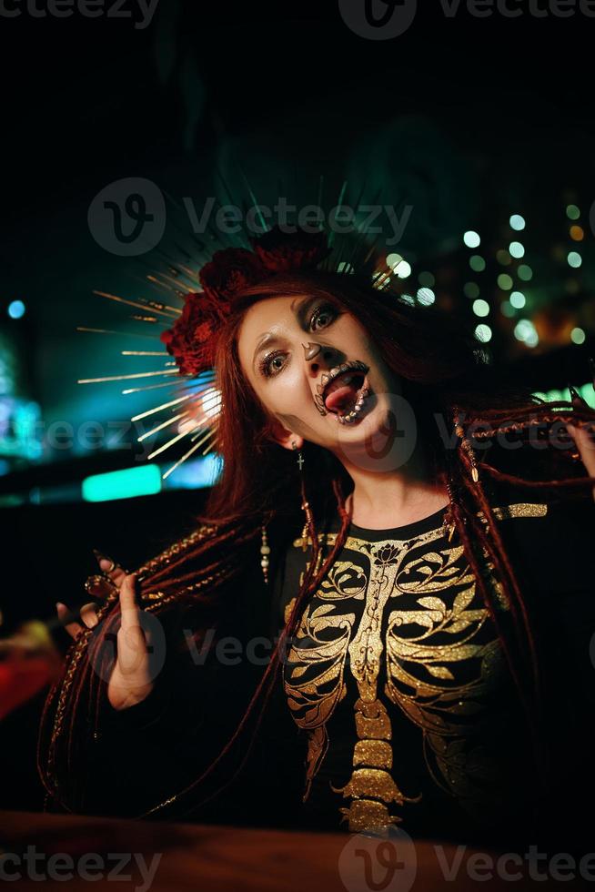 une femme avec un maquillage squelette lors d'une fête d'halloween fait des grimaces. photo