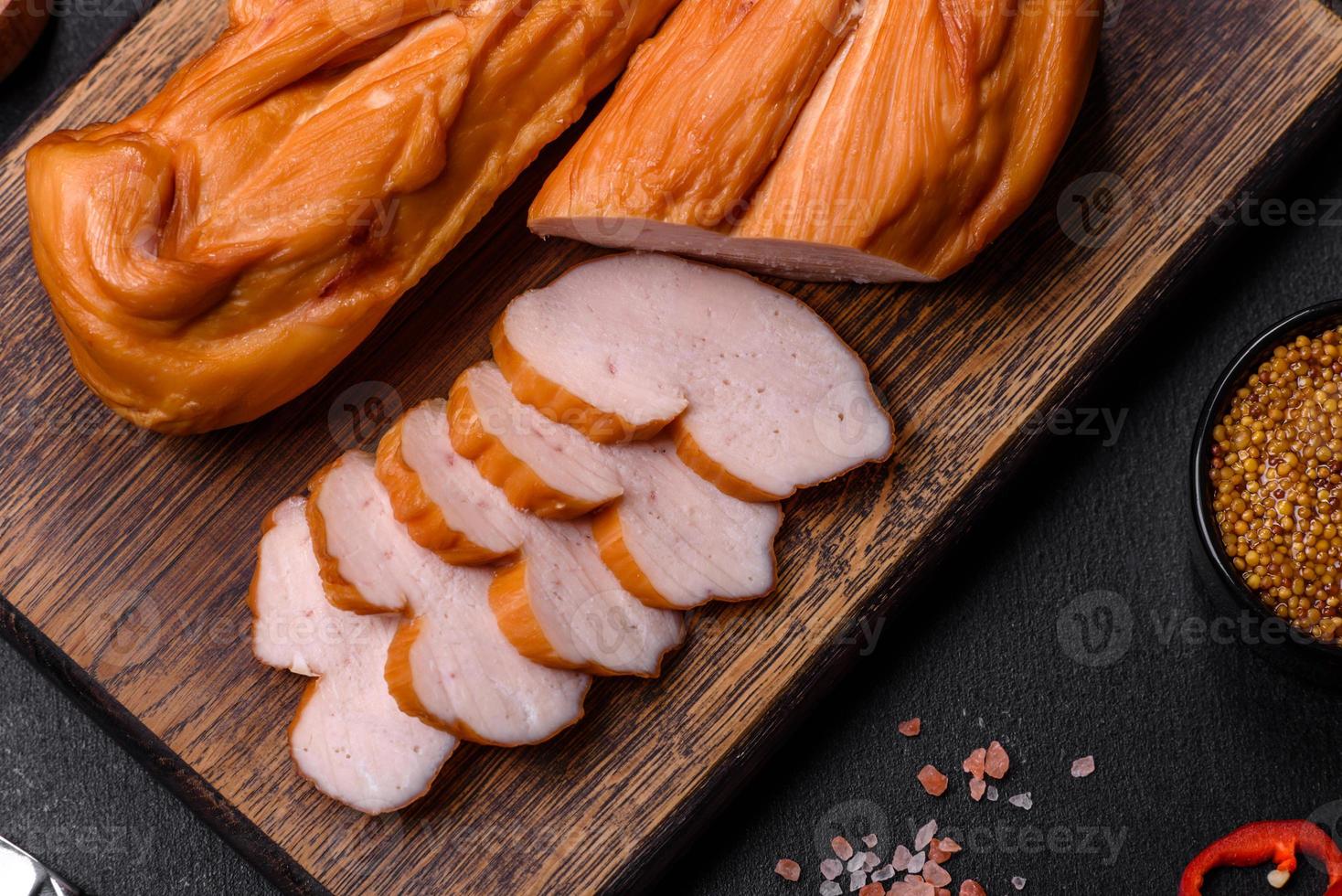 savoureux filet de poitrine de poulet fumé aux épices et herbes sur une planche à découper en bois photo