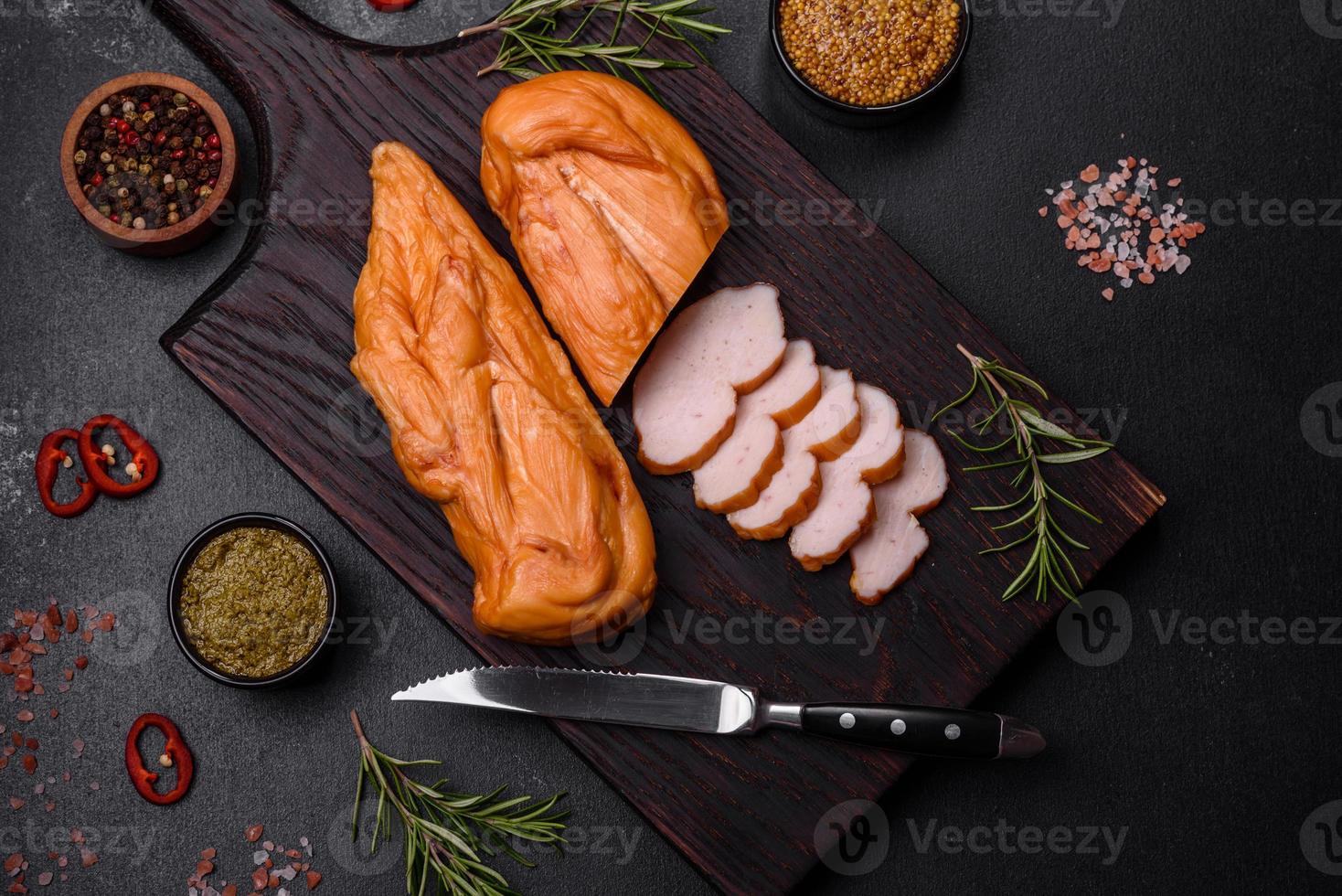 savoureux filet de poitrine de poulet fumé aux épices et herbes sur une planche à découper en bois photo