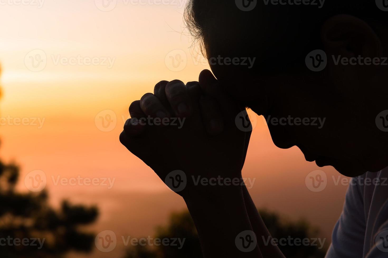 la foi du concept chrétien la prière spirituelle remet le soleil avec un beau fond de lever ou de coucher de soleil flou. chrétiens qui croient, foi en la prière du matin de dieu. photo