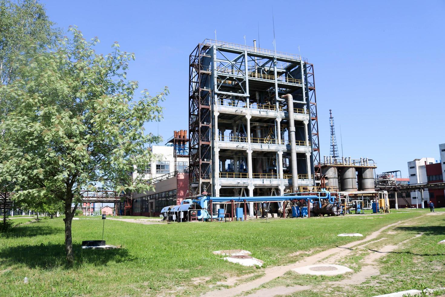 une grande installation industrielle technologique en béton dans une raffinerie chimique pétrochimique avec des tuyaux capacitifs par des pompes des compresseurs des échangeurs de chaleur par des pipelines et des bâtiments photo