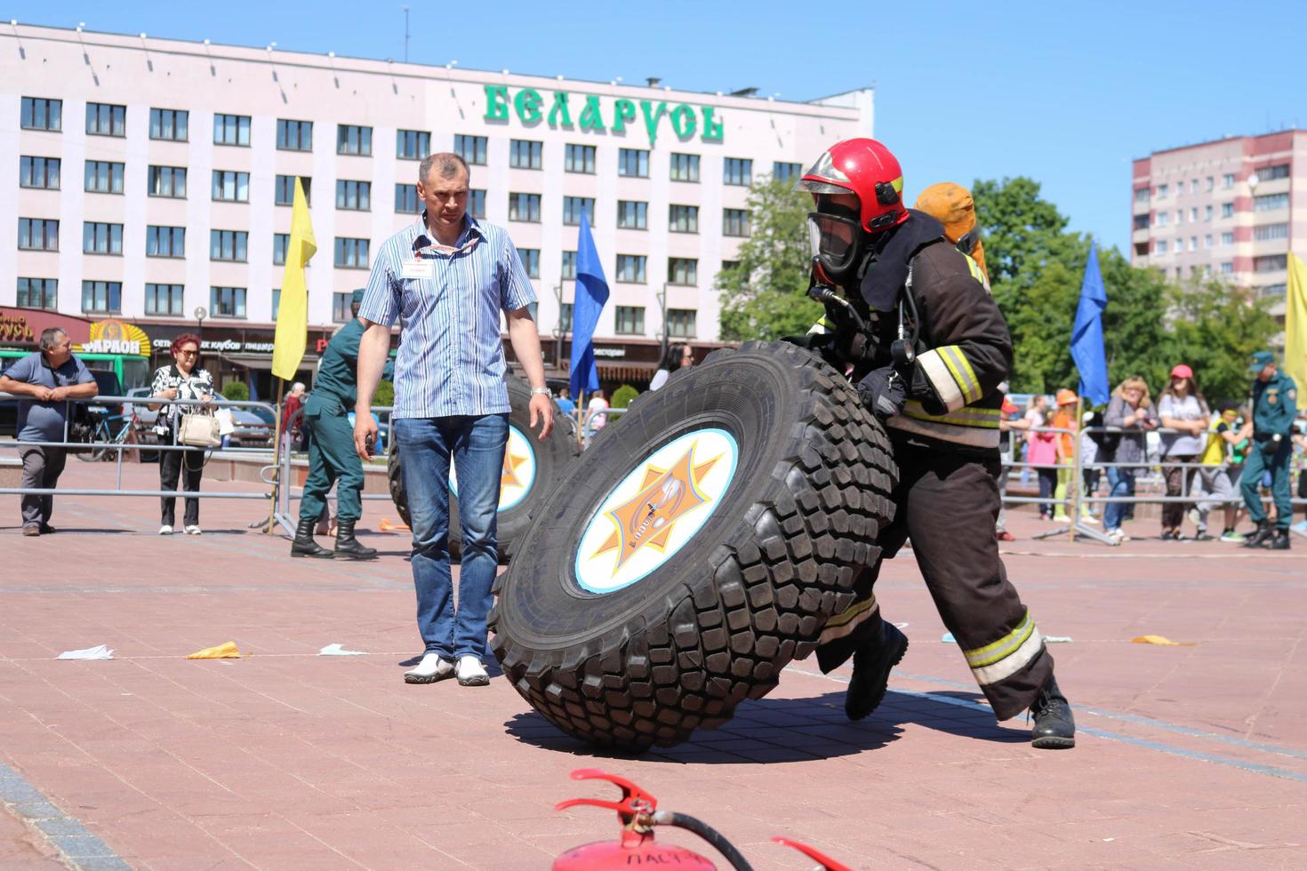 un pompier dans une combinaison ignifuge et un casque court et tourne une grande roue en caoutchouc dans un concours de lutte contre l'incendie, biélorussie, minsk, 08.08.2018 photo