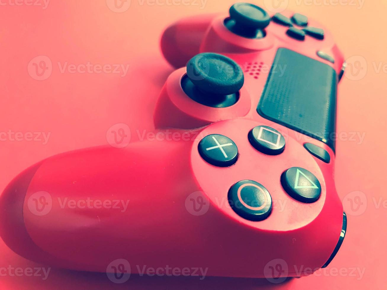 belle nouvelle manette de jeu moderne numérique rouge pour manette de jeux vidéo sur ordinateur sur fond rouge photo