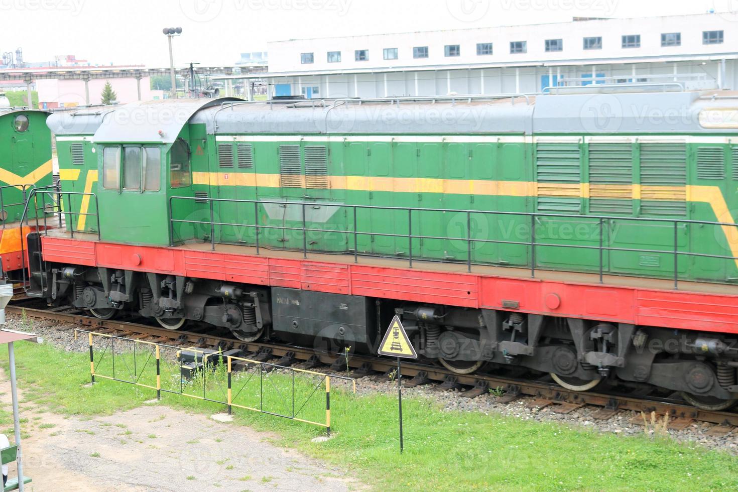 Train de marchandises à roues en fer métallique vert, locomotive pour le transport de marchandises sur rails à la gare photo