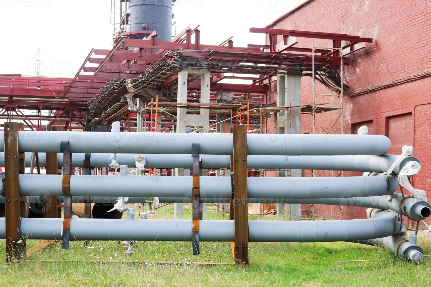 un grand chevalet de tuyauterie en métal de fer avec des tuyaux et des fils électriques et des équipements à la raffinerie industrielle de la raffinerie pétrochimique photo