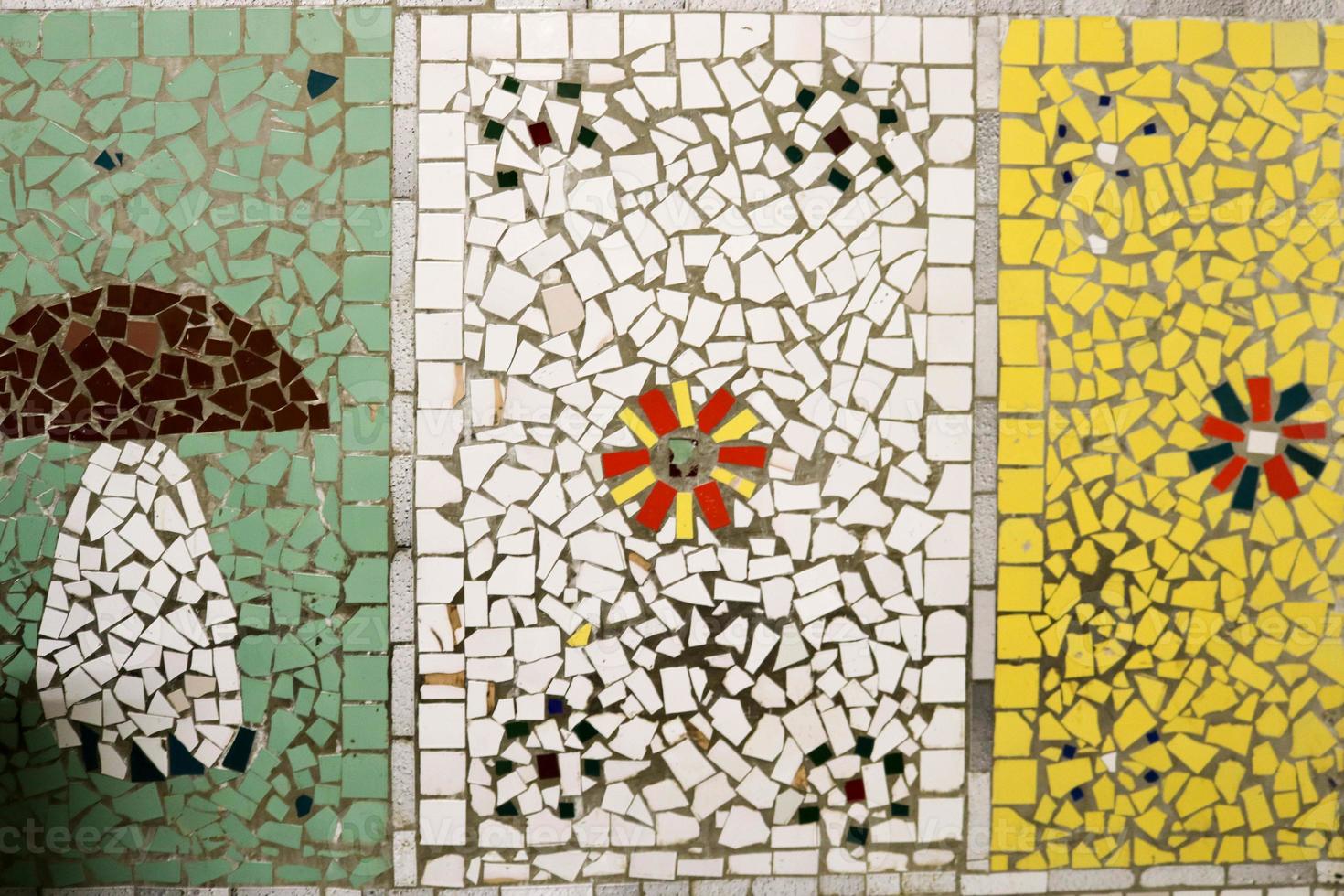 texture d'une mosaïque en céramique de fragments de verre de différentes couleurs avec un motif de fleurs et un champignon. l'arrière-plan photo