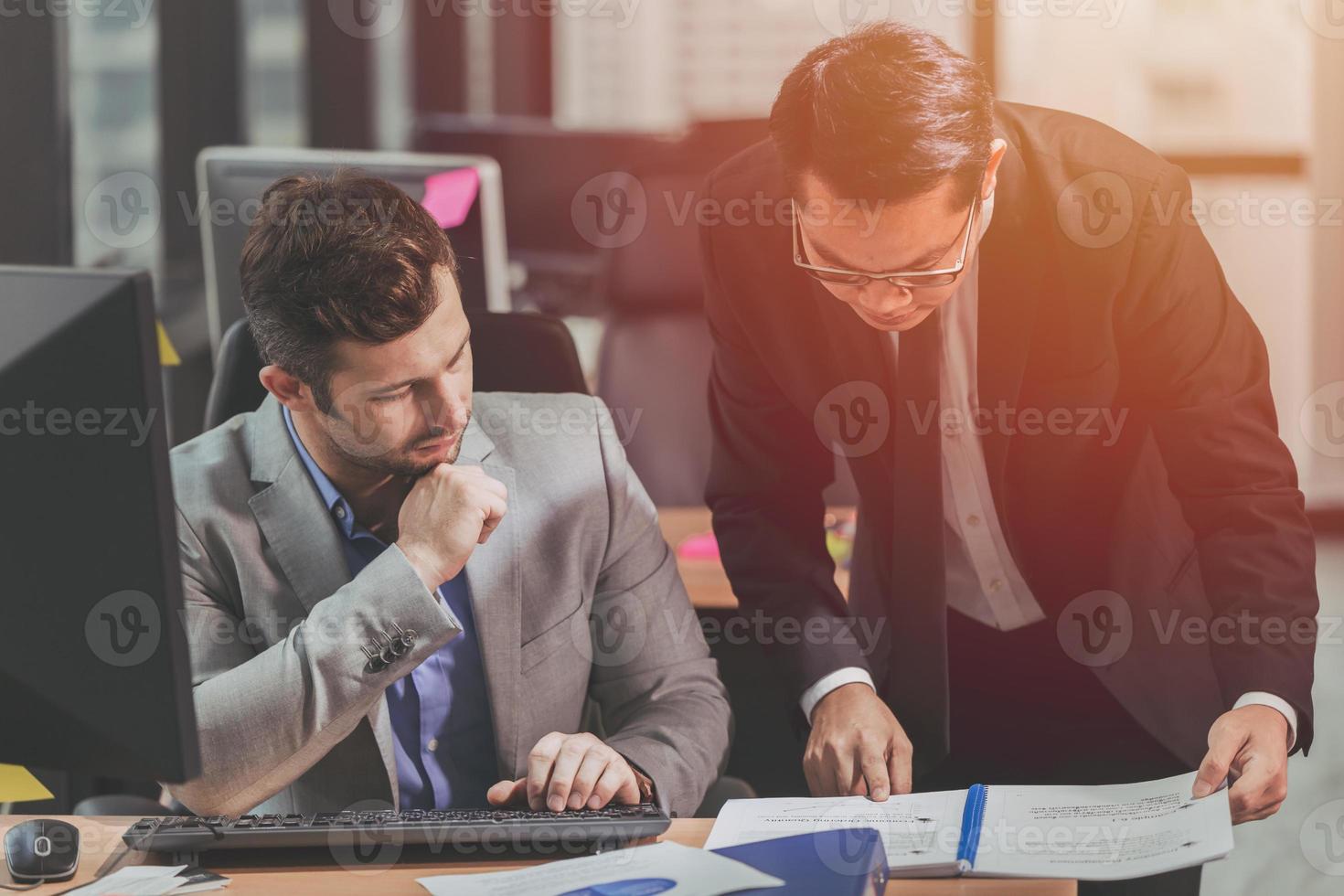 deux hommes d'affaires parlant avec un partenaire de race mixte asiatique et caucasien, patron exécutif travaillant aider à prendre soin de l'employé au bureau. photo