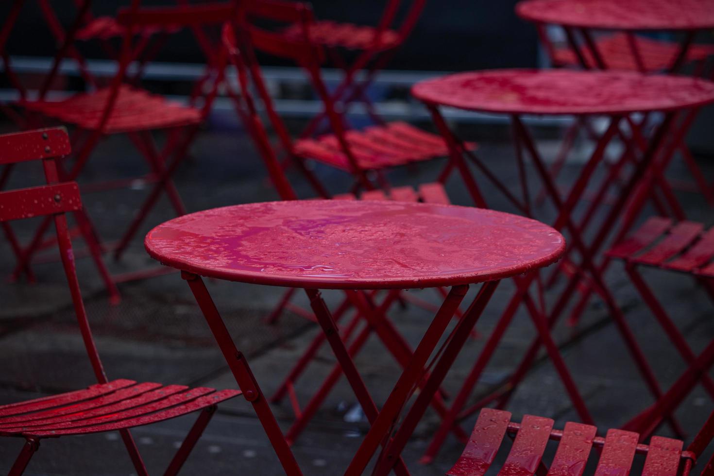 tables et chaises rouges mouillées par la pluie photo