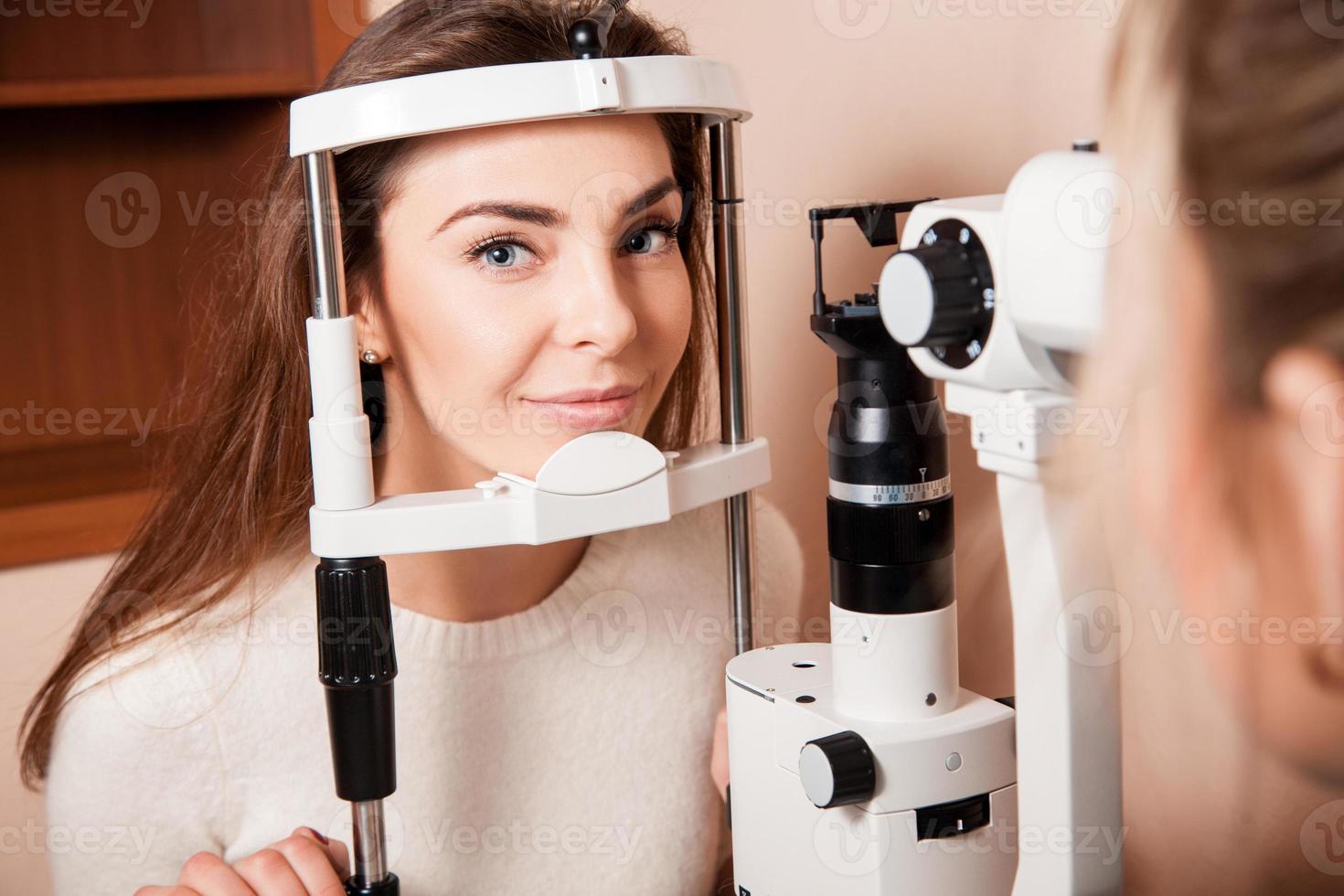 belle jeune femme adulte subit un examen de la vue effectué par un ophtalmologiste photo