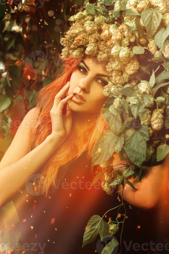 portrait magique d'une belle jeune femme avec une couronne de houblon sur la tête photo