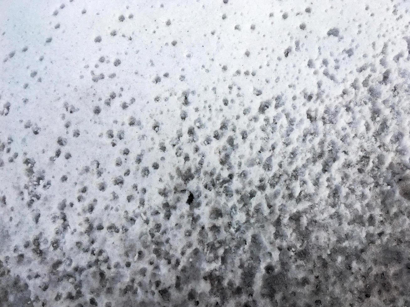 empreintes de pas dans la neige de gouttes d'eau. gouttes au printemps photo