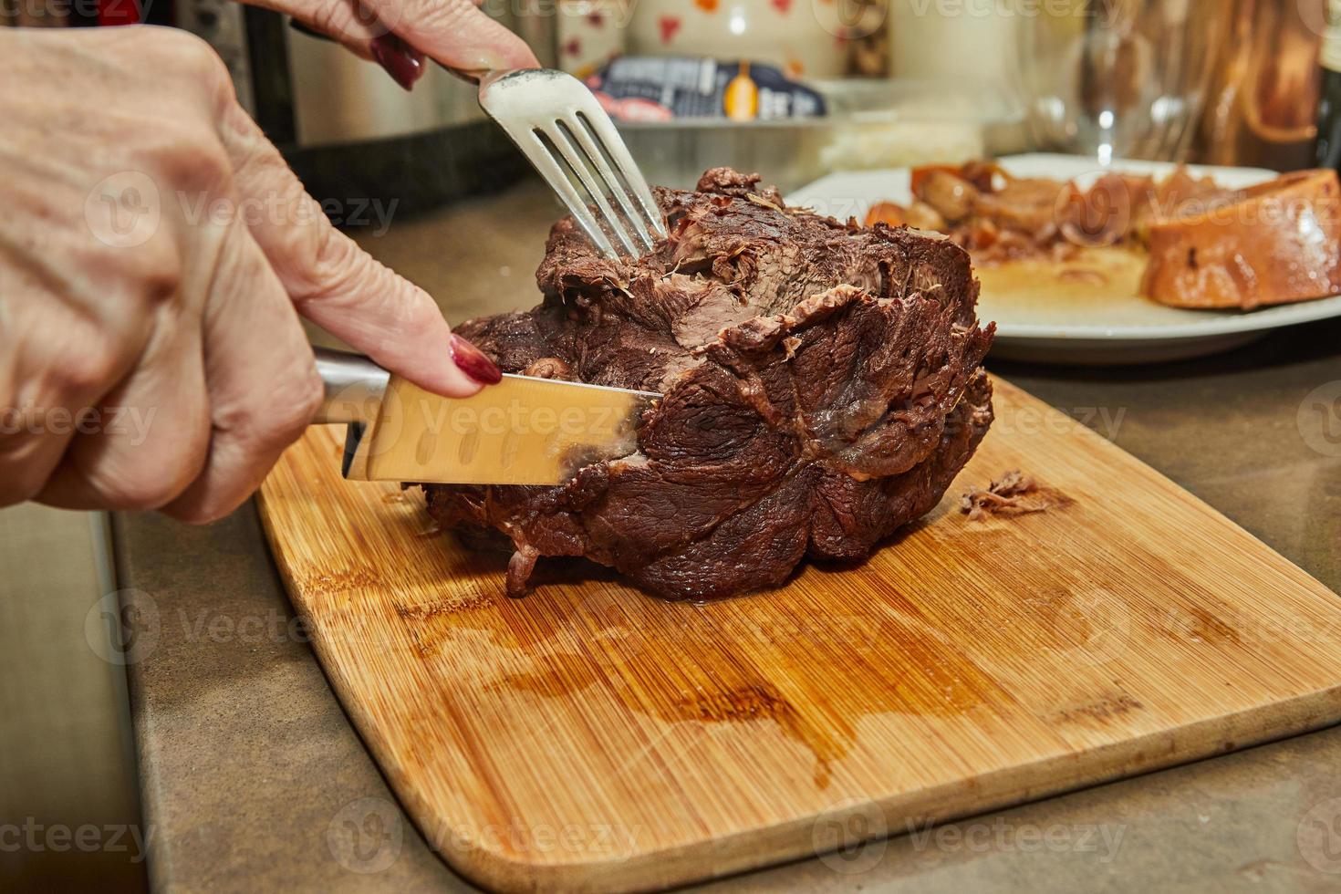 le chef coupe des tranches de morceau de boeuf cuit longtemps photo