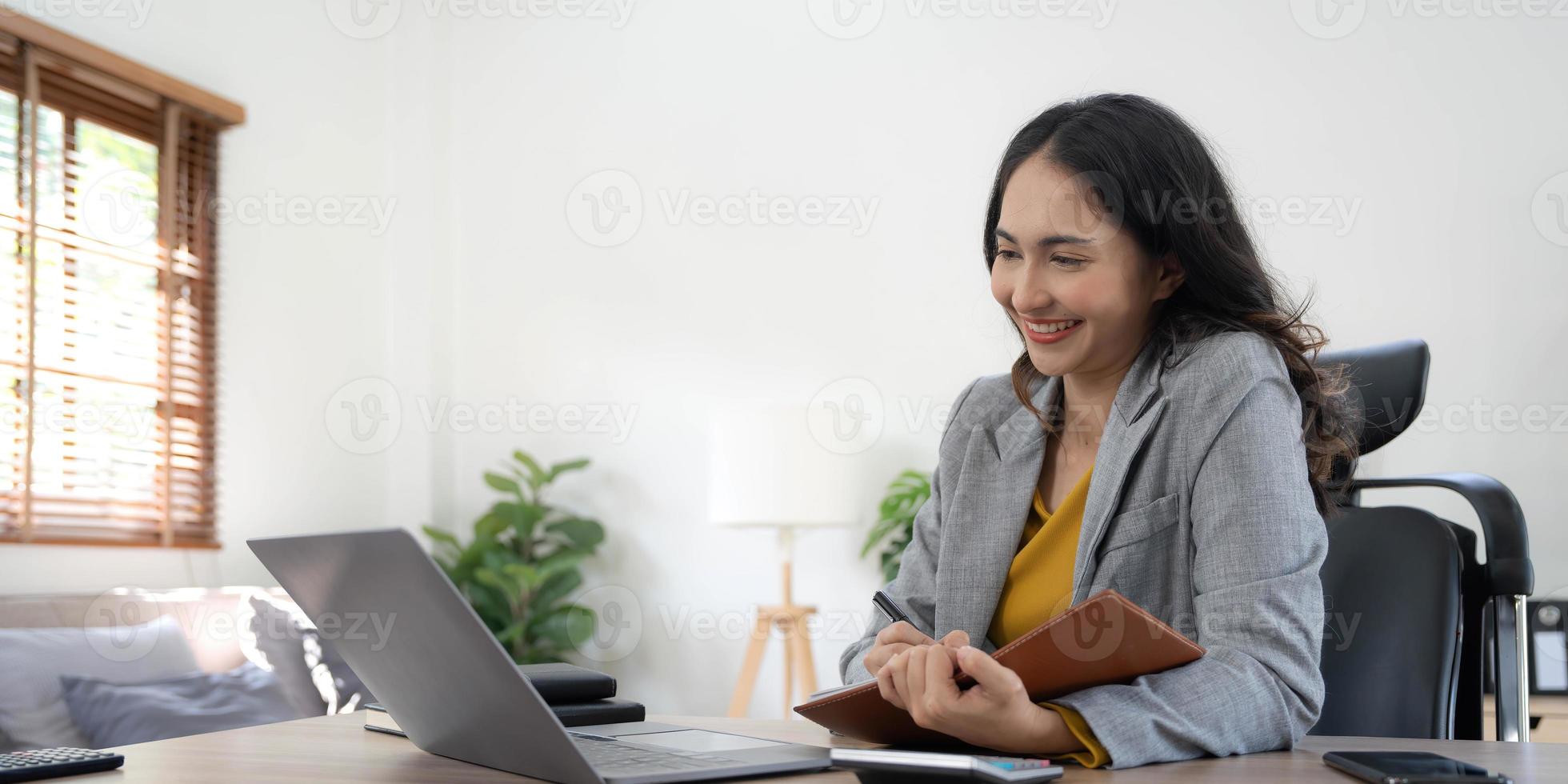 portrait d'une jeune femme d'affaires asiatique travaillant sur un ordinateur portable dans son poste de travail. concept de marketing de rapport en ligne indépendant employé de gens d'affaires. photo