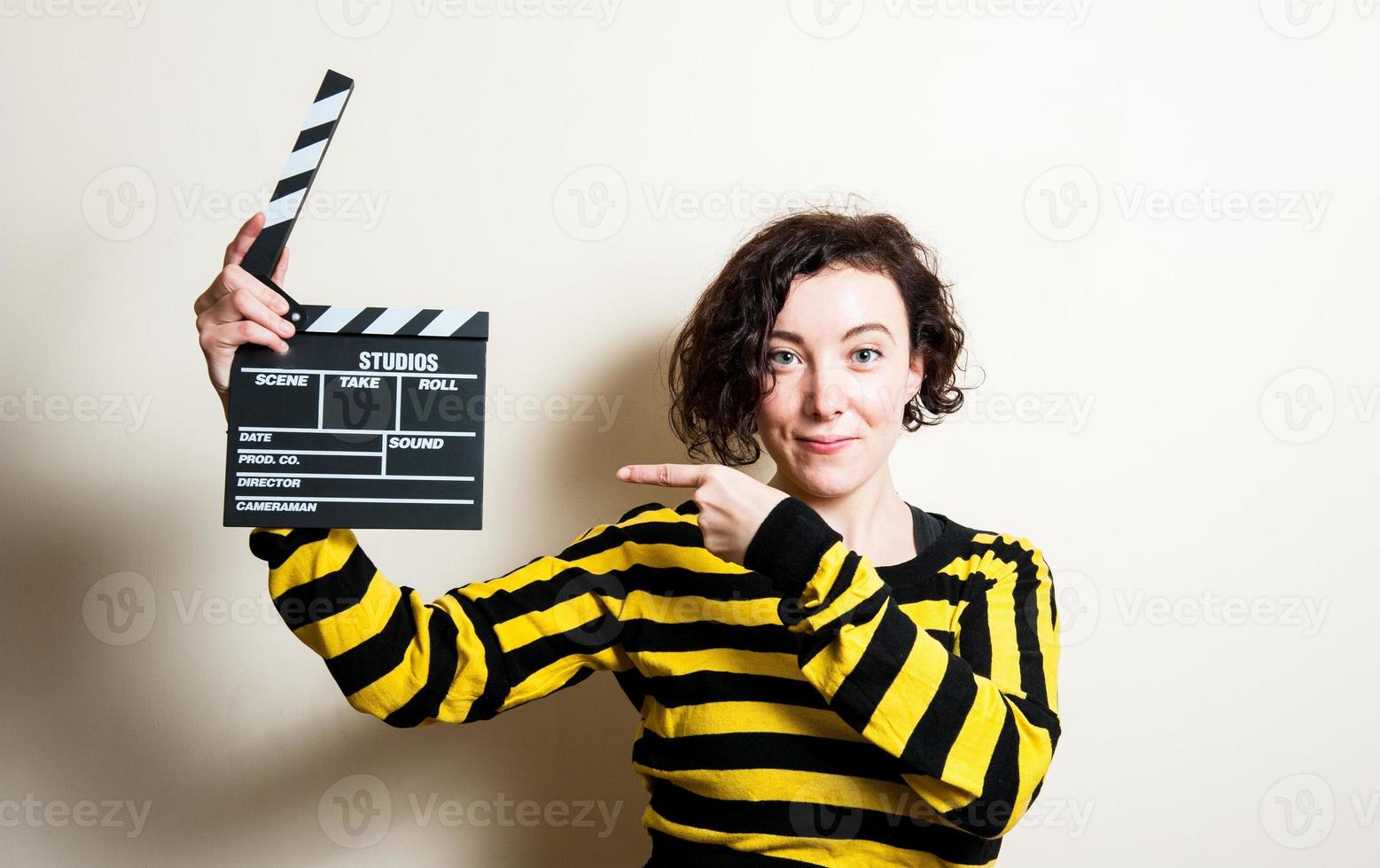 Girl smiling soulignant le battant de film sur fond blanc photo