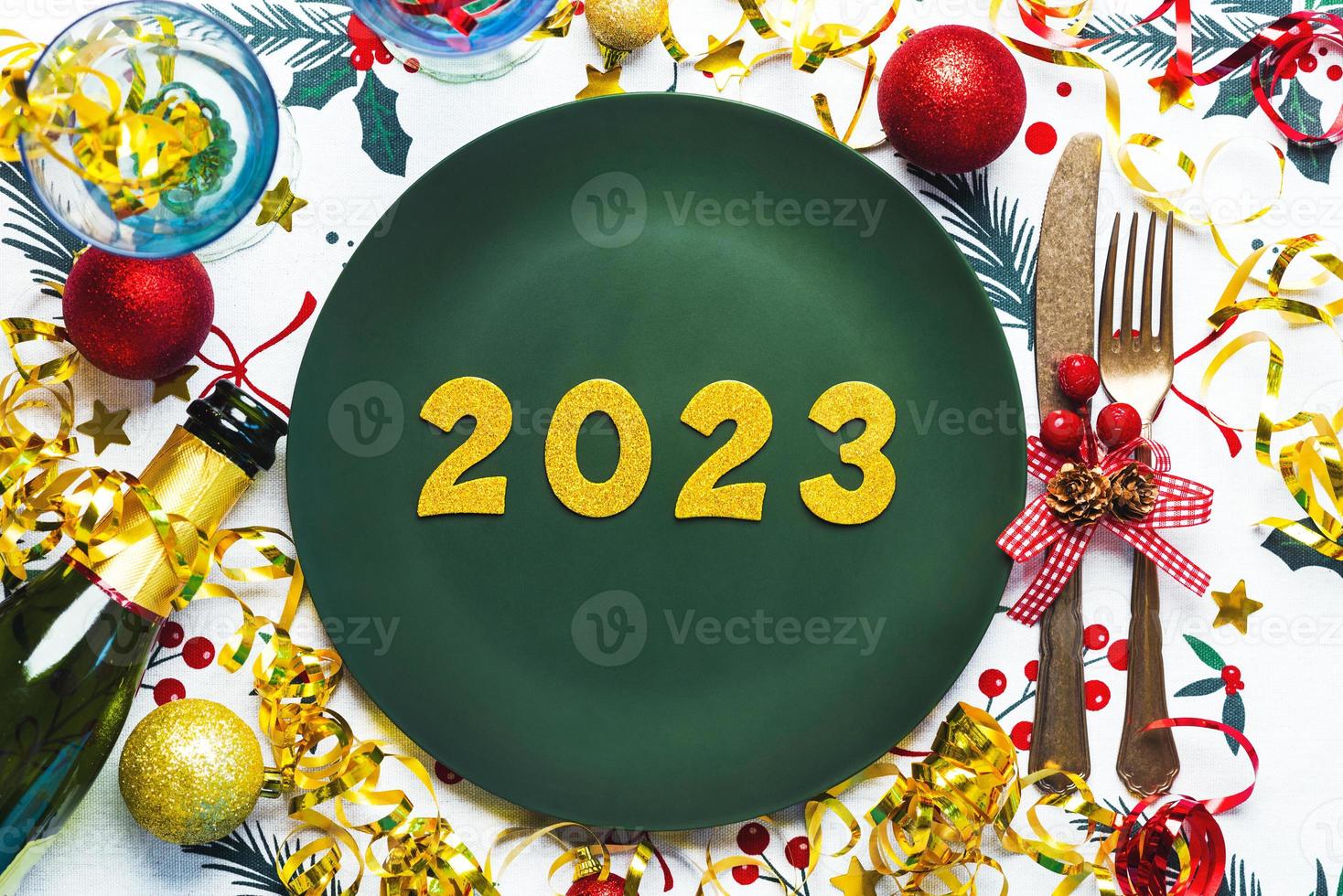 bonne année 2023. vue de dessus des nombres d'or 2023 sur assiette pour le dîner de noël avec décoration de noël et bouteille de champagne. fond de concept de célébration du nouvel an photo