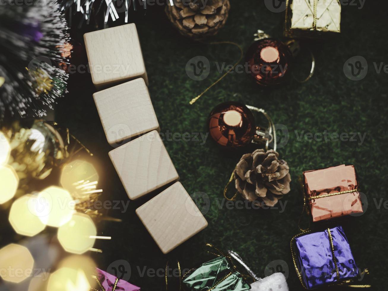 arbre de noël et boules de boîte-cadeau. guirlandes bokeh en arrière-plan flou. bloc de cube pour contenir le but de faire des affaires à surmonter. développer des idées pour la nouvelle année 2023 photo