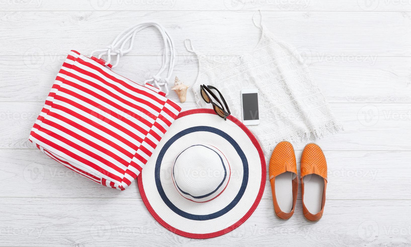 chapeau d'accessoires d'été et sac sur fond en bois blanc. photo