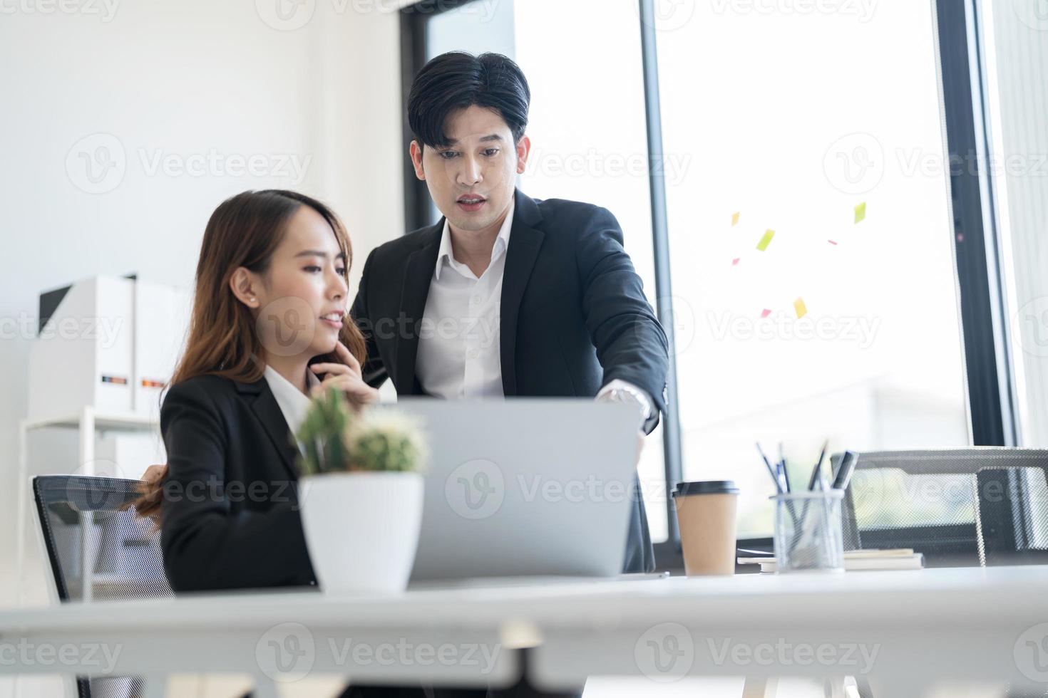 les gens d'affaires discutent ensemble d'entreprises commerciales en visualisant des informations via un ordinateur portable photo