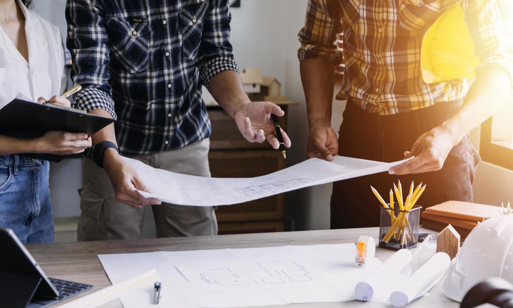 ingénieur en construction travaillant au plan directeur pour construire de grands bâtiments commerciaux au bureau. outils d'ingénierie et concept de construction. photo