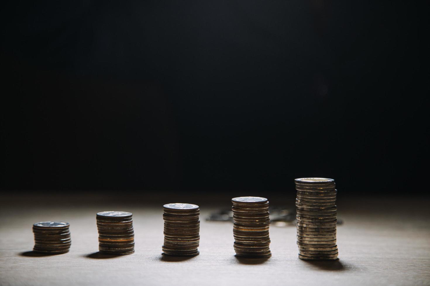 main de femme d'affaires calculant son argent à la fin du mois avec pièce de monnaie, calculatrice et calendrier sur table en bois photo