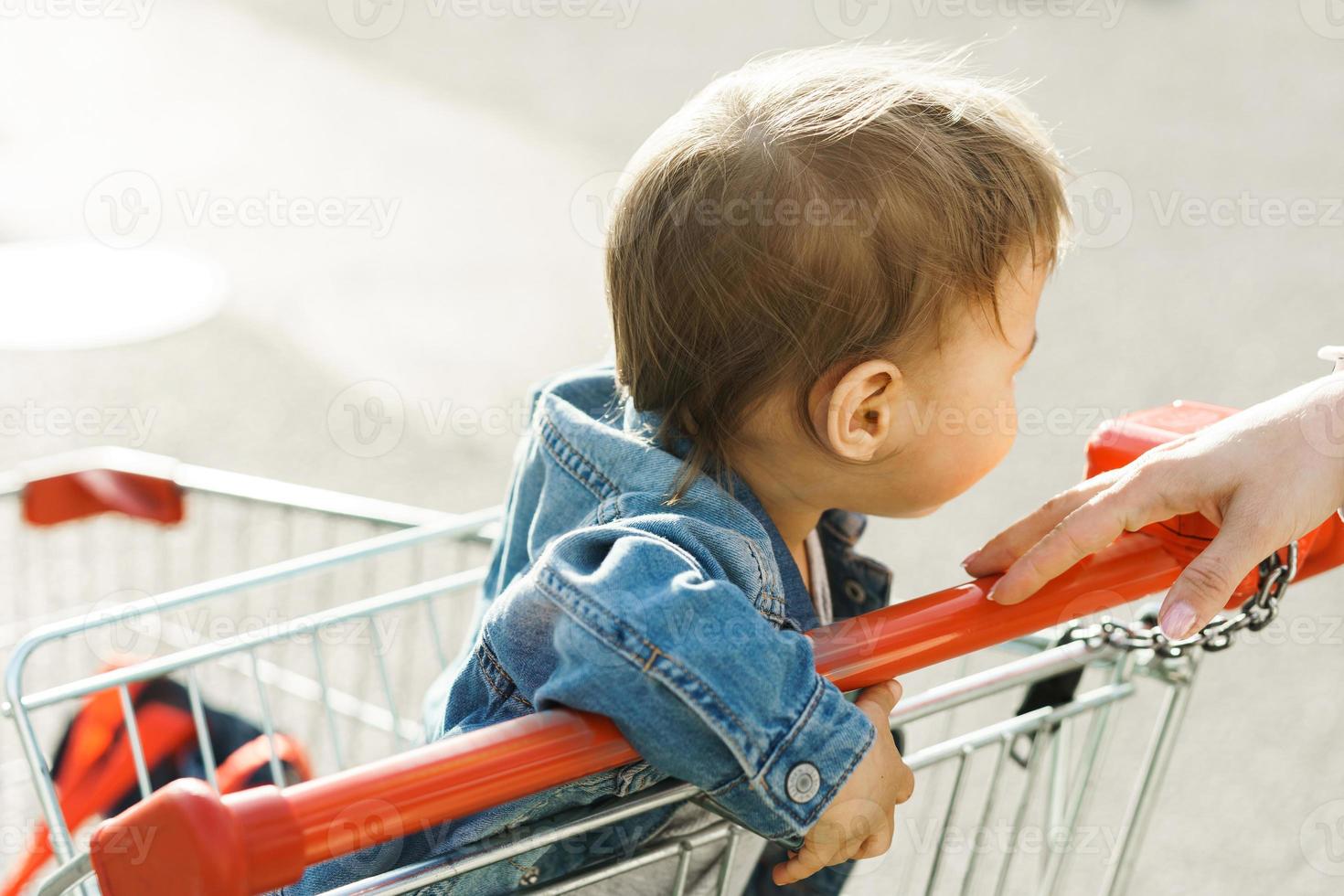 mignon petit garçon assis dans un panier photo